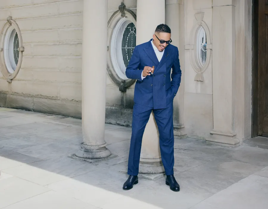 Navy double-breasted suit against a stone colonnade