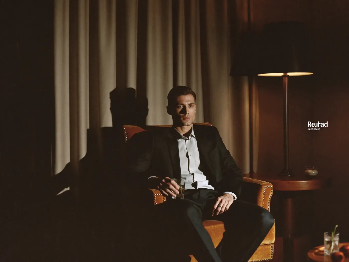 Editorial portrait — seated at a desk, warm lamp light