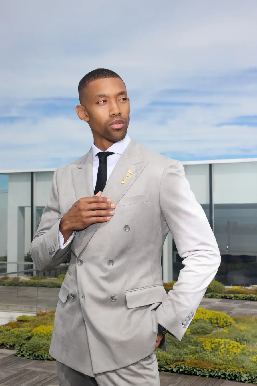 Light grey double-breasted suit, adjusting the jacket